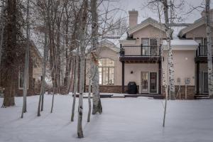 une maison dans la neige avec des arbres devant elle dans l'établissement The Woodland Townhome - Located on Ski Hill Road, à Driggs
