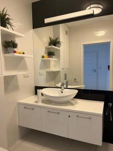 a white bathroom with a sink and a mirror at airport cybernetyki2 inn in Warsaw