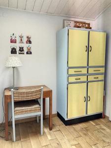 Cette chambre comprend une table et un réfrigérateur jaune. dans l'établissement La Siesta, à La Rochelle
