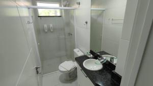a white bathroom with a sink and a shower at 131 - Bombas Summer Beach depto 1 dormitorio para 4 con amenities in Bombinhas +14 photos