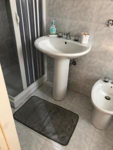 a bathroom with a sink and a shower and a toilet at Alloggio Turistico Casa di Luca e Vale in Campotosto