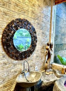 a bathroom with a sink and a mirror on the wall at PONDOK KUNGKANG VILLA 2 in Ubud