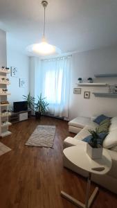 uma sala de estar com um sofá e uma mesa em Loving My Rooms 2 - delizioso appartamento in centro em Gorizia