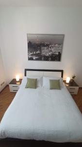 um quarto com uma grande cama branca e 2 candeeiros em Loving My Rooms 2 - delizioso appartamento in centro em Gorizia