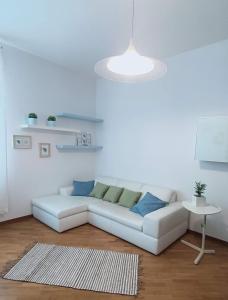 uma sala de estar com um sofá branco e uma mesa em Loving My Rooms 2 - delizioso appartamento in centro em Gorizia