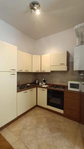 a kitchen with white cabinets and a stove top oven at Loving My Rooms 2 - delizioso appartamento in centro in Gorizia