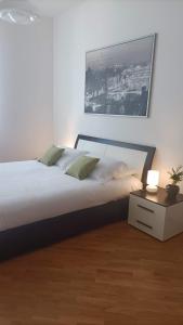 um quarto com uma cama com uma mesa de cabeceira e uma fotografia em Loving My Rooms 2 - delizioso appartamento in centro em Gorizia