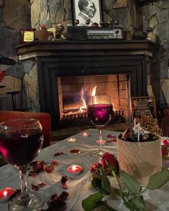 two glasses of wine on a table with a fireplace at TATİL KEYFİ MOTEL in Kocaeli