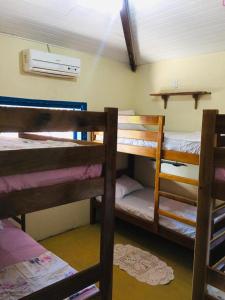 a room with three bunk beds and a window at Hostel Jericoacoariano in Jericoacoara