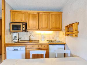 kuchnia z drewnianymi szafkami i białymi urządzeniami w obiekcie Charmant appartement 3 pièces, terrasse, ski à proximité - FR-1-425-135 w mieście Flaine +4 zdjęcia