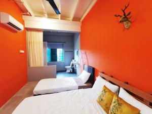 Duas camas num quarto com uma parede laranja em Ipoh town centre - safari 5 pax(2BR) em Ipoh