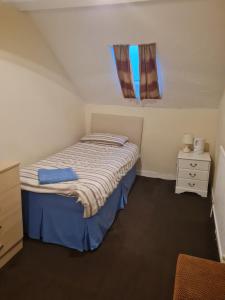 Habitación pequeña con cama y ventana en Durham house hotel, en Gateshead