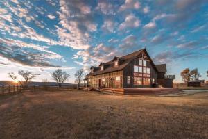 a house on a field with a cloudy sky at Postcard Views, Teton Valley Id in Tetonia