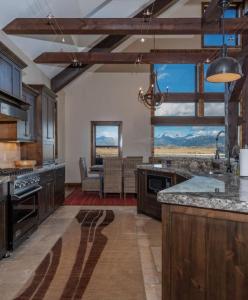 a large kitchen with wooden cabinets and a large window at Postcard Views, Teton Valley Id in Tetonia
