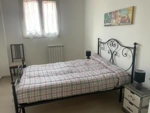 una camera da letto con un letto con una coperta a quadri e due finestre di BORGO PESCI a Roma