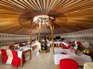 restauracja ze stołami i krzesłami oraz dużym sufitem w obiekcie Sara's Camp w mieście Dzuunmod