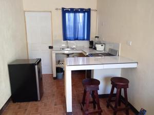 a kitchen with a counter and two bar stools at Villas El Alto 3 in Tambor