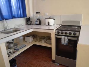 a small kitchen with a stove and a sink at Villas El Alto 3 in Tambor