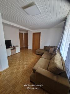 a living room with a couch and a television at Monteurwohnungen - Monteurunterkunft in Randersacker bei Würzburg in Randersacker