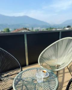 2 sillas y una mesa de cristal en el balcón en Bergpanorama Lodge — Alpenidylle en Thaur