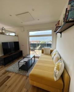 sala de estar con sofá y TV de pantalla plana en Bergpanorama Lodge — Alpenidylle, en Thaur