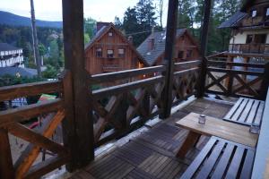 eine Holzterrasse mit einer Bank darüber in der Unterkunft I Zimą I Latem in Szklarska Poręba