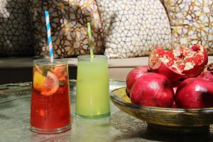 twee drankjes op een tafel naast een fruitschaal bij Riad Emberiza Sahari in Marrakesh