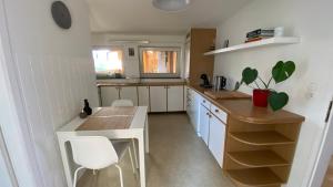 eine Küche mit weißen Schränken sowie einem Tisch und Stühlen in der Unterkunft Wohnung am Spitalberg in Klagenfurt am Wörthersee