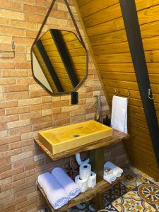 uma casa de banho com um lavatório de madeira e um espelho em Chalé Miraflores em São Martinho com vista para as montanhas em São Martinho