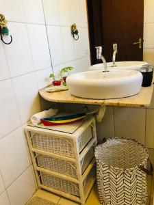 een badkamer met een wastafel en een aantal manden bij Casa riviera in Paraty