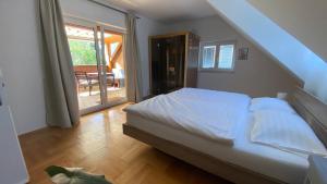 um quarto com uma cama com lençóis brancos em Wohnung am Spitalberg em Klagenfurt