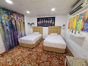 2 camas en una habitación con un mural en amazing view large dunes nearby, en Liwa