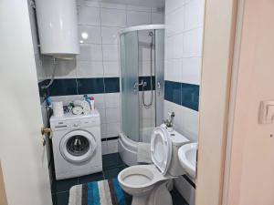 a bathroom with a toilet and a washing machine at Apartman Odmor012 in Požarevac