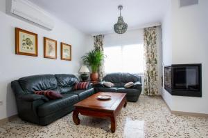 Sala de estar con 2 sofás de cuero y mesa de centro en Newly furnished cozy house next to the beach en Calafell