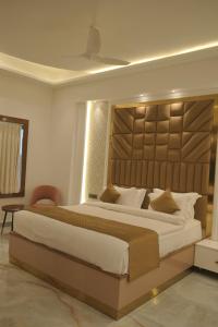 アリーガルにあるGolden Stone Resortsのベッドルーム1室(大型ベッド1台、大型ヘッドボード付)