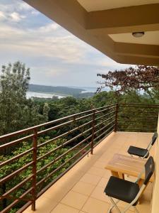 a balcony with a wooden table and two chairs at The Address Resort in Kalangala