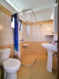 a bathroom with a toilet and a sink at Sea Breeze Rooms in Himare
