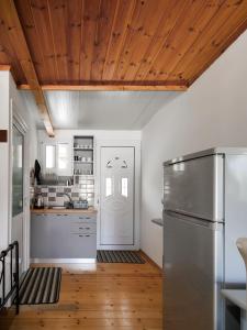 een keuken met een koelkast en een houten plafond bij Sea Breeze Rooms in Himare