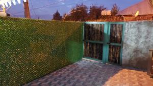 uma cerca verde com uma porta em frente em Femily em Tbilisi