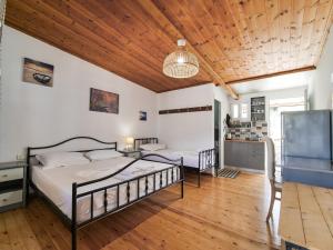 a bedroom with two beds and a wooden ceiling at Sea Breeze Rooms in Himare