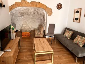 salon z kanapą i stołem w obiekcie Apartamentos El PELIGRO 3 LA CUEVA w mieście Archidona