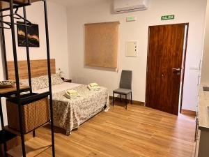 Habitación con cama y suelo de madera. en Apartamentos El PELIGRO 3 LA CUEVA en Archidona