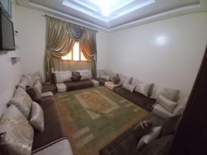 ein Wohnzimmer mit einem Sofa und einem Fenster in der Unterkunft إقامة الخيمة للشقق المفروشة in El Aaiún