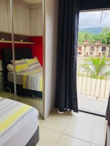 een slaapkamer met een bed en een groot raam bij Casa riviera in Paraty