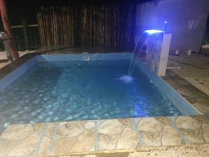 a swimming pool with a water fountain at night at Villas El Alto 1 in Tambor