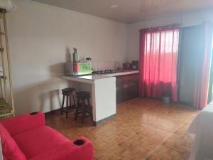 a living room with a red couch and a kitchen at Villas El Alto 1 in Tambor