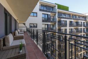 ブダペストにあるK40 Double Bedroom in the City Centerのソファと椅子が置かれたアパートのバルコニー