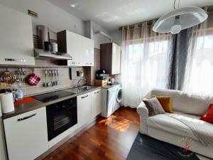 - une cuisine avec des placards blancs et un canapé dans la chambre dans l'établissement Premier Apartment Milano, à Milan