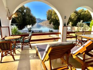 a patio with tables and chairs and a view of the water at Villa Evdokia in Kalymnos