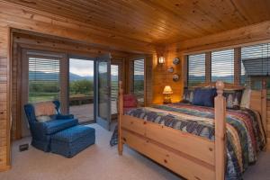 a bedroom with a bed and a chair in a cabin at Teton Riverfront Property in Victor